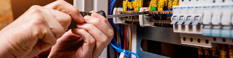 The man is repairing the switchboard voltage with automatic switches. Electrical background